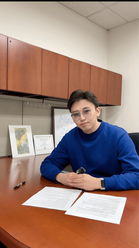 Person in office with documents and awards.