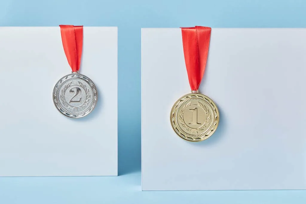 Gold and silver medals with red ribbons against a blue backdrop representing achievement and success.